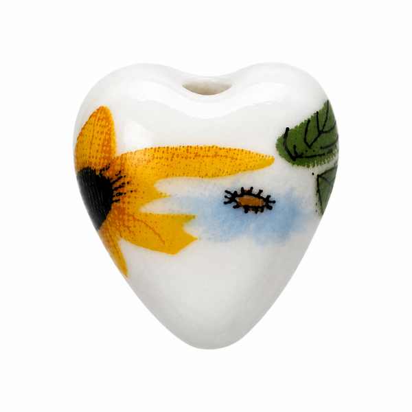 Heart-shaped ceramic charm with floral design on a white background