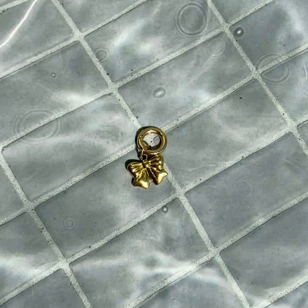Gold swimsuit charm with bow charm