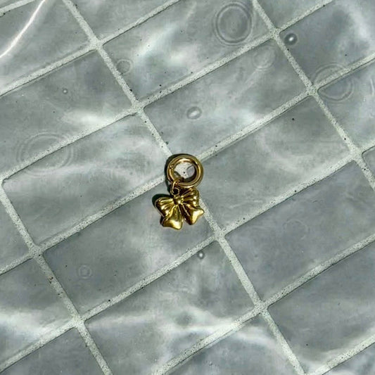 Gold swimsuit charm with bow charm