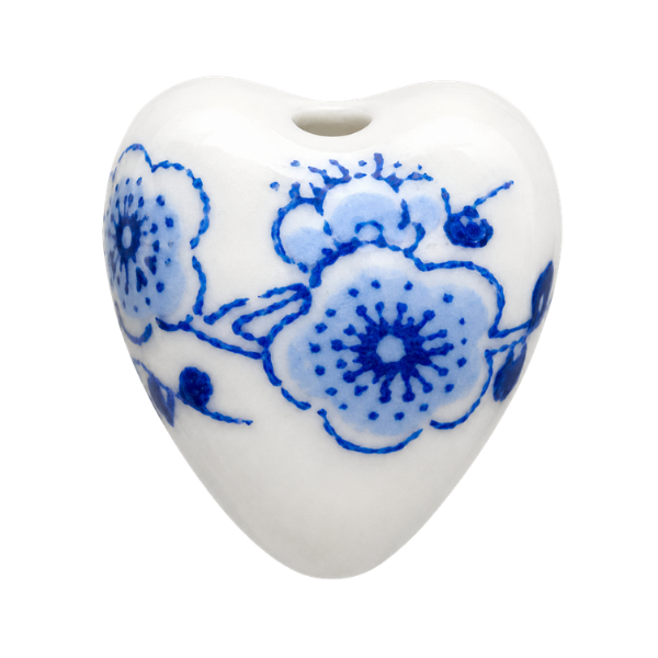 Heart-shaped ceramic pendant with blue floral patterns on a white background